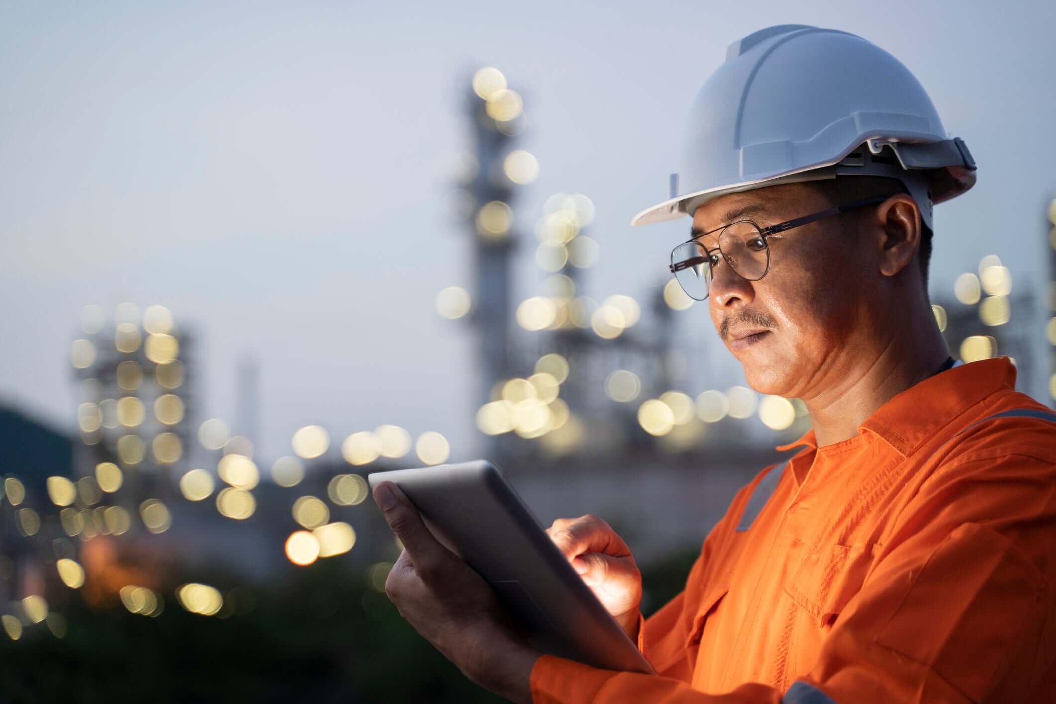 Engineer is collecting data of oil refinery through his laptop.