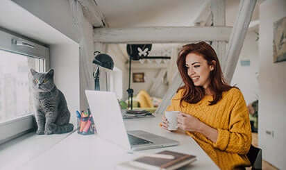 A lady holding coffee mug is talking to a team member on a call