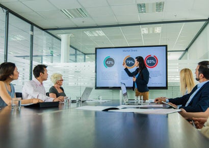 A business women is giving presentation to the team