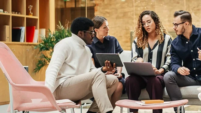 Group of people discussing while analysing the data using tab and laptop