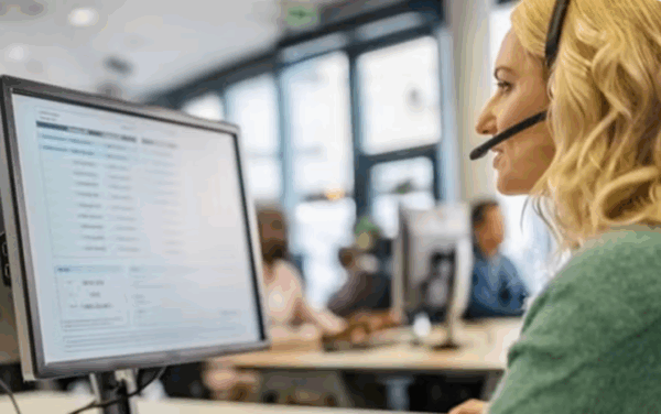 Support Call center in office Woman on headset at desktop