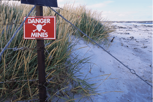 Beach with 'danger mines' warning signage