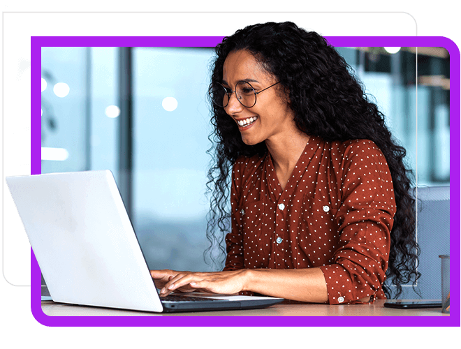 young woman working and smiling at laptop.